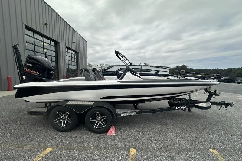 The Image of 2021 Caymas CX 19 boat on trailer, parked outside a building under cloudy skies. - 1