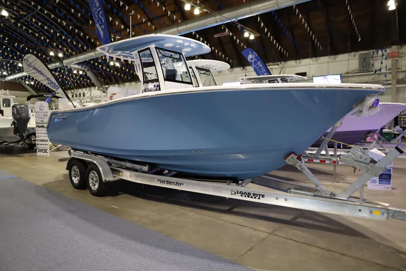 The Image of 2026 Sportsman Open 252 Center Console boat displayed indoors on a trailer. - 0