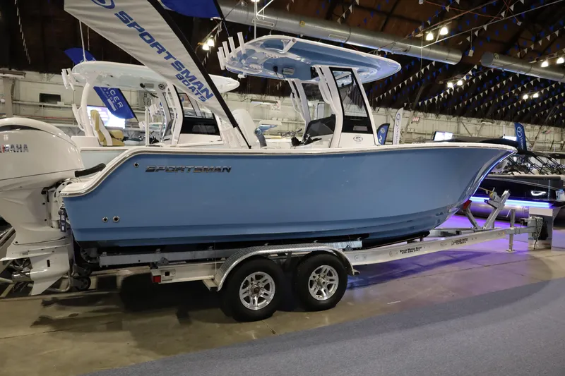 Slide: The Image of 2026 Sportsman Open 252 Center Console boat displayed indoors on a trailer. - 1