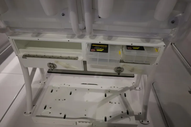 Slide: The Image of 2026 Sportsman Open 252 Center Console storage compartments with tackle boxes and secure latches. - 17