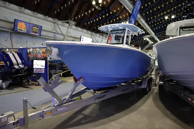 Slide: The Image of 2026 Sportsman Open 252 Center Console boat displayed indoors on a trailer. - 2