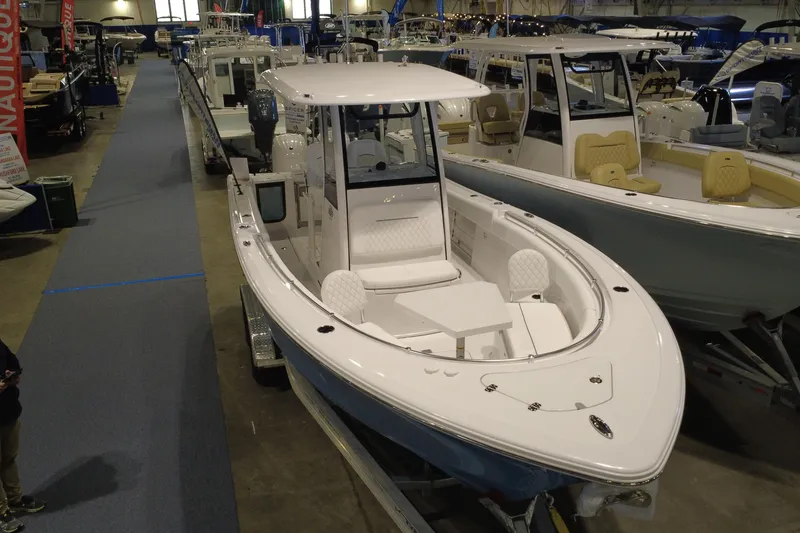 Slide: The Image of 2026 Sportsman Open 252 Center Console boat displayed at an indoor boat show. - 7