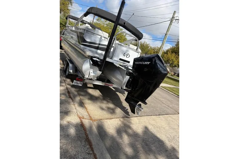 Slide: The Image of 2023 Avalon Venture 85 Quad Lounge boat with Mercury engine on a trailer. - 2