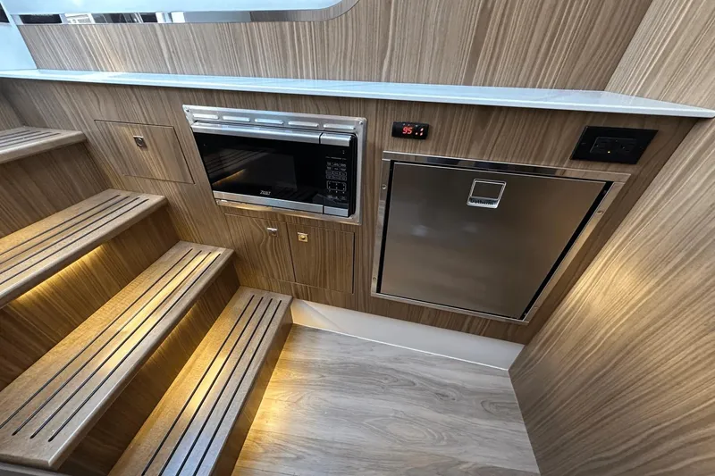 Slide: The Image of 2024 Cruisers Yachts 50 GLS interior with microwave and stainless steel fridge. - 14