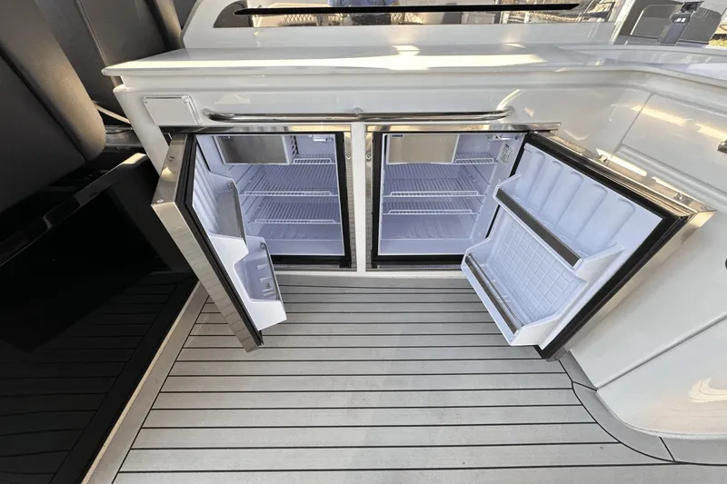 Slide: The Image of 2024 Cruisers Yachts 50 GLS with open dual refrigerators on sleek deck. - 23
