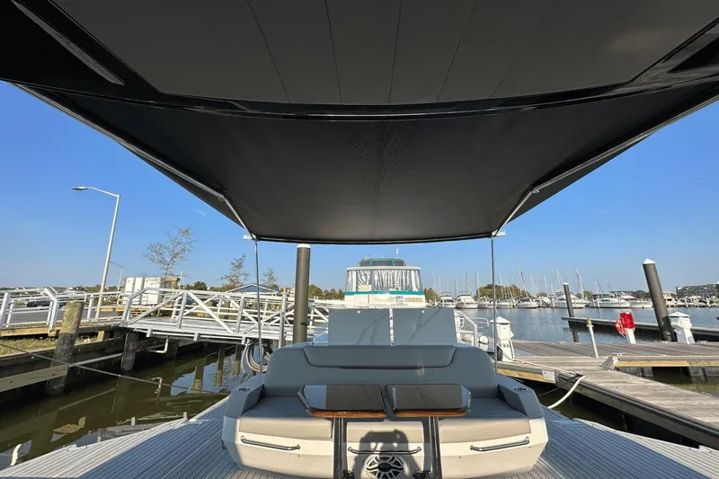 Slide: The Image of 2024 Cruisers Yachts 50 GLS at marina, featuring spacious deck and canopy. - 29