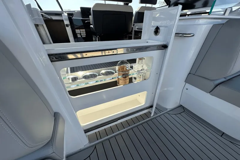 Slide: The Image of 2024 Cruisers Yachts 50 GLS interior with built-in beverage storage and seating area. - 34