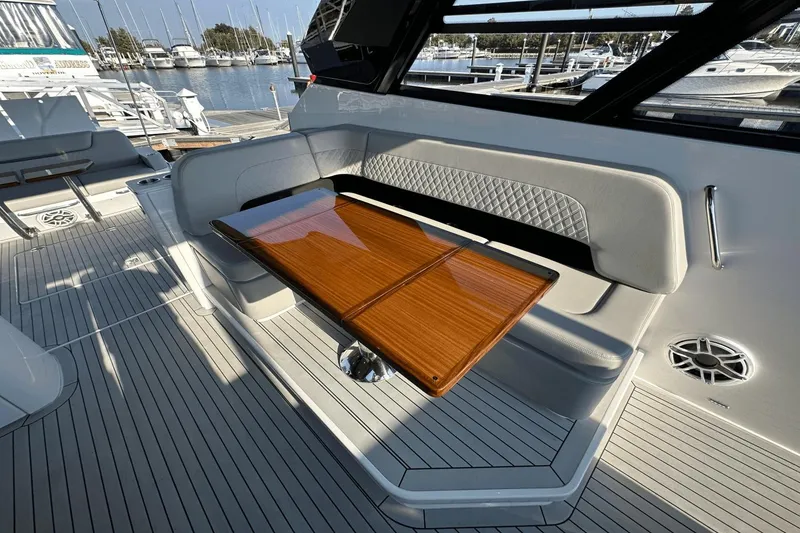 Slide: The Image of Luxurious seating area on 2024 Cruisers Yachts 50 GLS with elegant wooden table. - 35