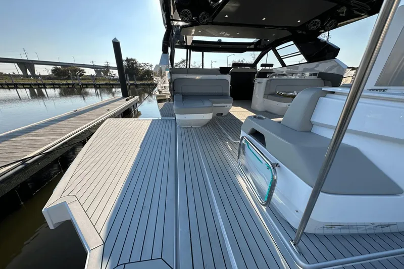 Slide: The Image of 2024 Cruisers Yachts 50 GLS luxury deck with seating, docked by the water. - 37