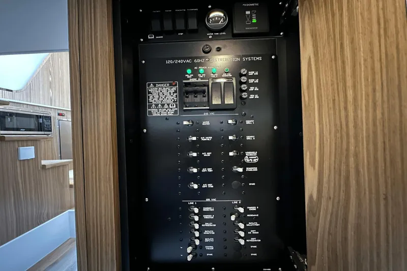 Slide: The Image of Electrical control panel inside 2024 Cruisers Yachts 50 GLS, featuring various switches and indicators. - 40
