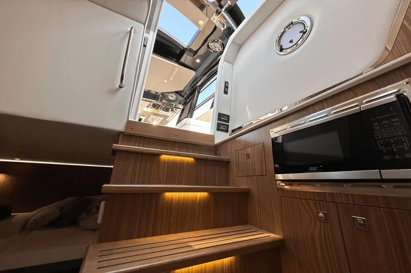 Slide: The Image of Interior view of 2024 Cruisers Yachts 50 GLS, featuring wooden stairs and modern amenities. - 44