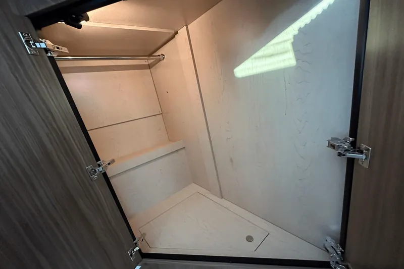 Slide: The Image of 2024 Cruisers Yachts 50 GLS interior closet with wooden finish and metal rod. - 45