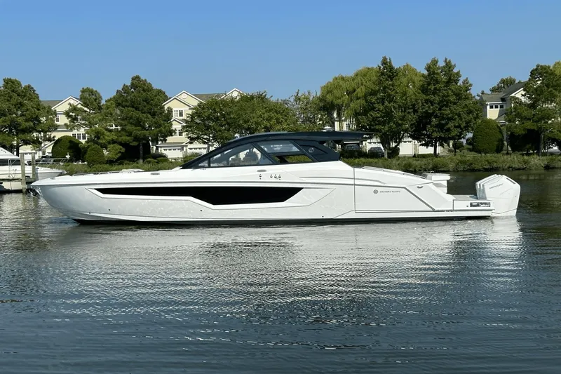 Slide: The Image of 2024 Cruisers Yachts 50 GLS luxury boat on a serene waterway. - 5