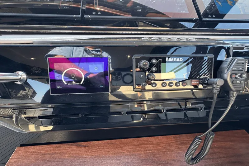 Slide: The Image of Control panel of 2024 Cruisers Yachts 50 GLS with Simrad and Seakeeper displays. - 51