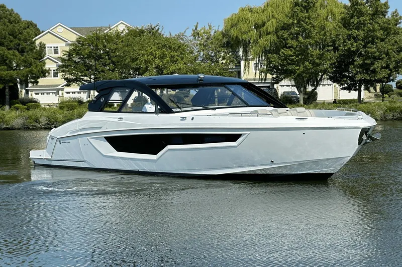 Slide: The Image of 2024 Cruisers Yachts 50 GLS luxury boat on a serene waterway. - 6
