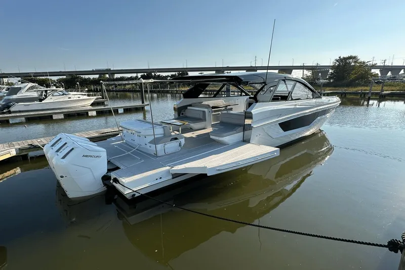 Slide: The Image of 2024 Cruisers Yachts 50 GLS luxury boat docked, featuring sleek design and powerful Mercury engines. - 9