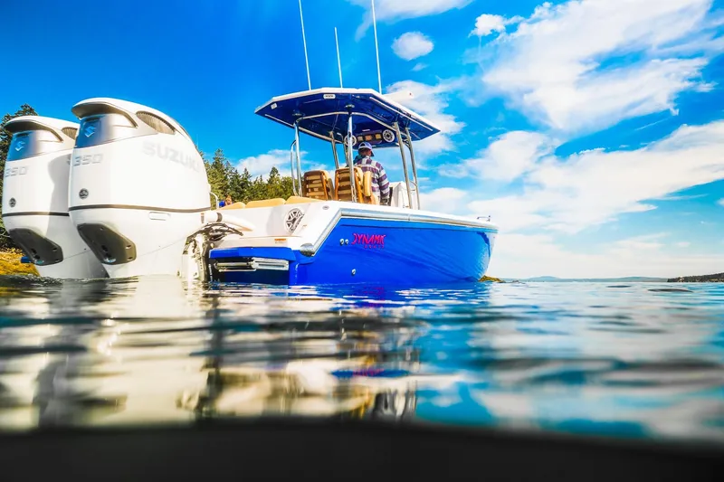 Slide: The Image of Blue Dynamic D-305V boat on water, featuring dual Suzuki engines, under a clear sky. - 7