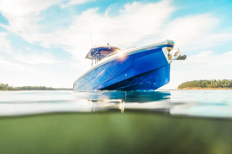 Slide: The Image of Blue Dynamic D-305V boat on calm water, 2023 model, under a clear sky. - 9