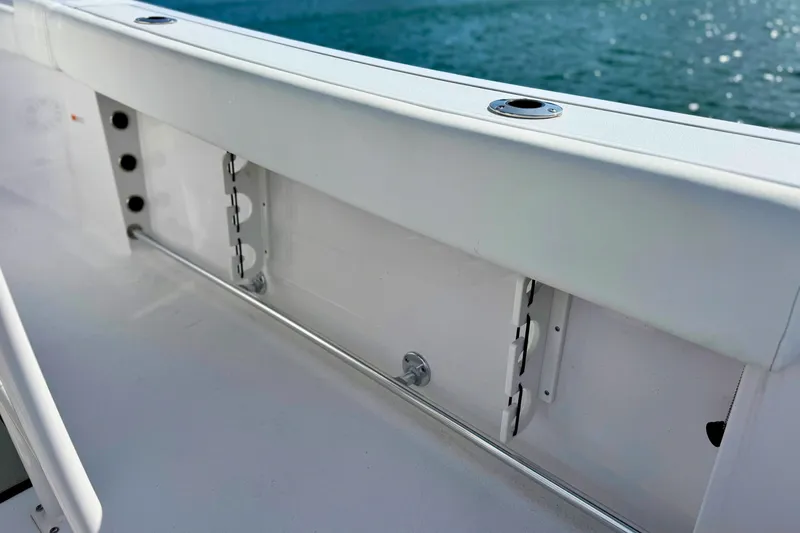 Slide: The Image of 2024 Sportsman Heritage 231 Center Console boat with cushioned seating and outboard motor on water. - 10