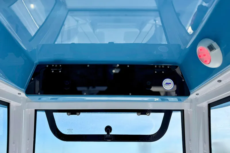 Slide: The Image of 2024 Sportsman Heritage 231 Center Console boat, rod holders and speakers, blue sky background. - 16