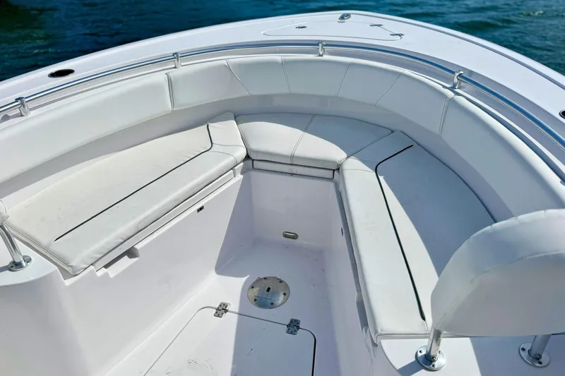 Slide: The Image of 2024 Sportsman Heritage 231 Center Console boat interior with white seating and ocean backdrop. - 20