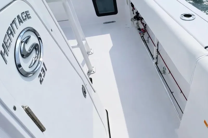 Slide: The Image of 2024 Sportsman Heritage 231 Center Console boat interior with cushioned seating and table. - 24