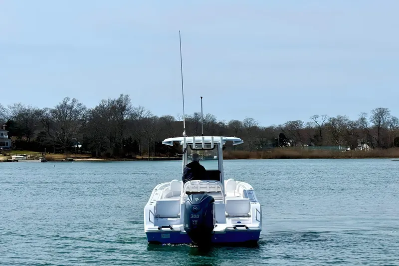 Slide: The Image of 2024 Sportsman Heritage 231 Center Console boat cruising on a sunny lake. - 7