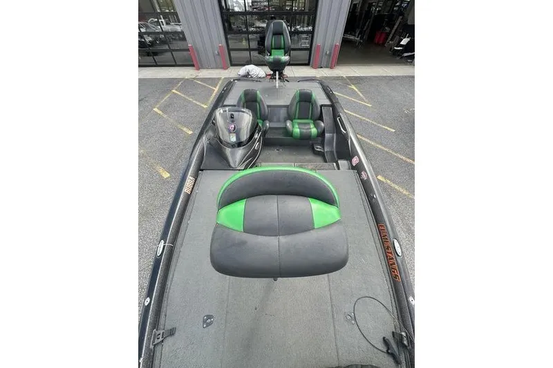 Slide: The Image of 2016 Stratos 294 XL Evolution boat with green and black seating, parked outdoors. - 11