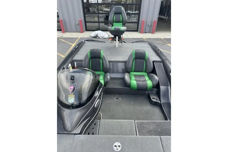 Slide: The Image of 2016 Stratos 294 XL Evolution boat with green and black seats, parked outside. - 7