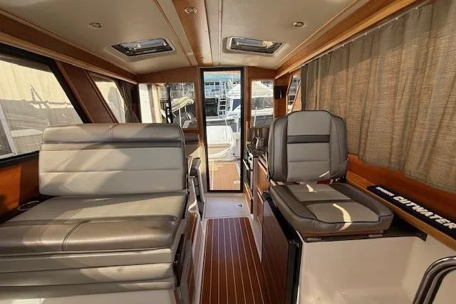 Slide: The Image of Interior of 2019 Cutwater 28 boat with leather seating and wood flooring. - 10