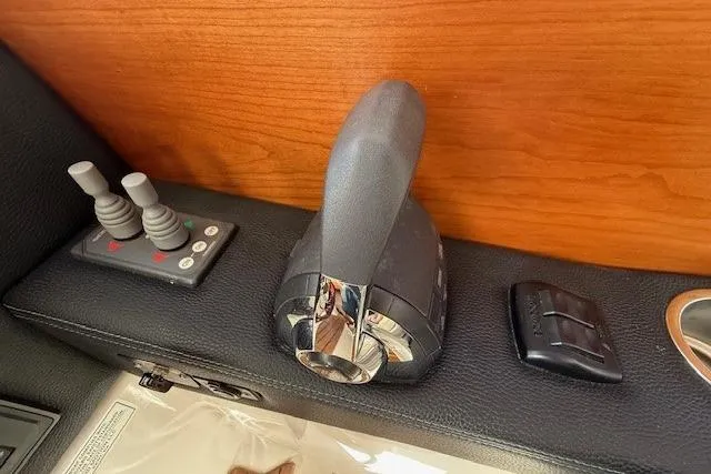 Slide: The Image of 2019 Cutwater 28 boat throttle and control panel on wooden dashboard. - 11