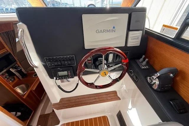 Slide: The Image of Helm of 2019 Cutwater 28 boat featuring Garmin navigation system and wooden steering wheel. - 12