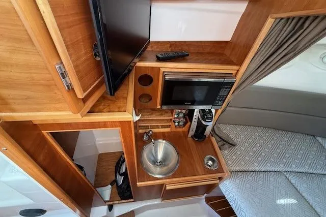 Slide: The Image of 2019 Cutwater 28 interior with kitchenette, sink, microwave, and TV. - 14