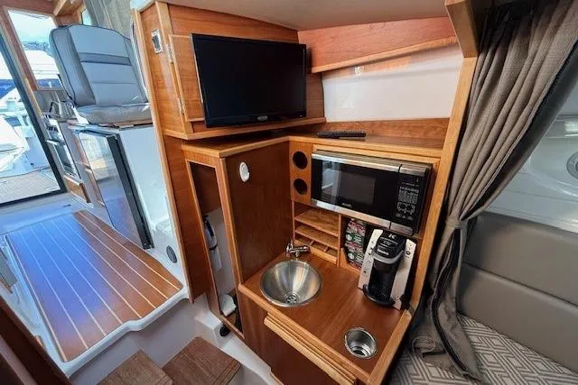 Slide: The Image of 2019 Cutwater 28 interior with kitchenette, TV, and seating area. - 15