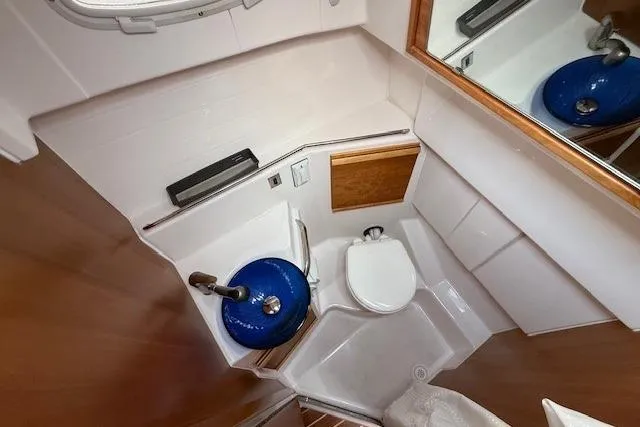 Slide: The Image of 2019 Cutwater 28 boat bathroom with blue sink, toilet, and mirror. - 17