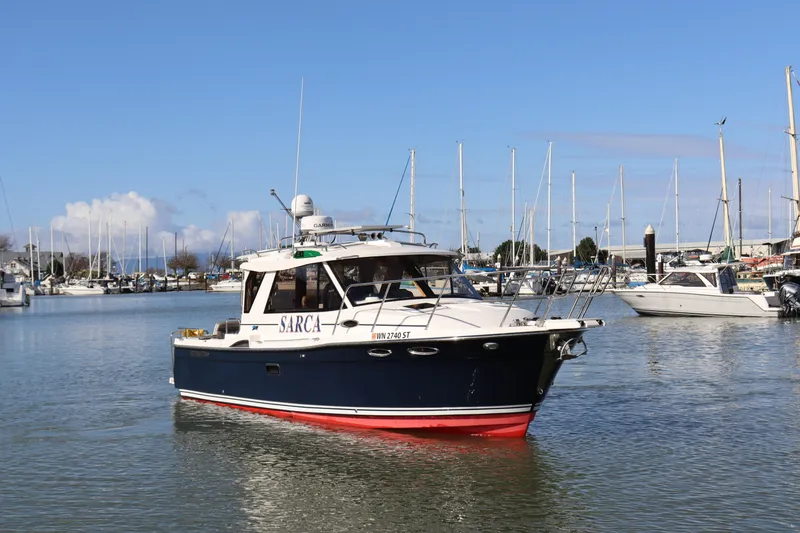 Slide: The Image of 2019 Cutwater 28 boat cruising in a marina with sailboats in the background. - 2