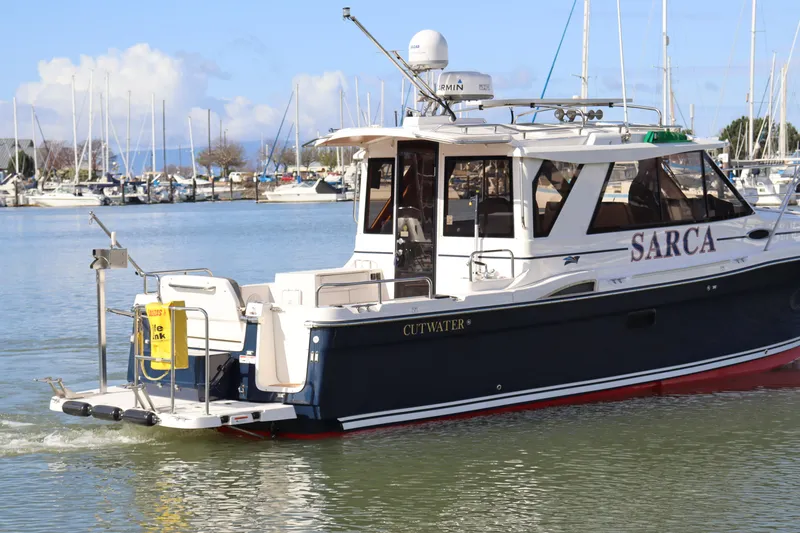 Slide: The Image of 2019 Cutwater 28 boat named Sarca docked in a marina with clear skies. - 4
