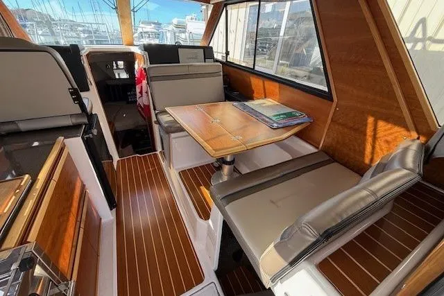 Slide: The Image of 2019 Cutwater 28 interior with wood accents, seating, and table in a well-lit cabin. - 7