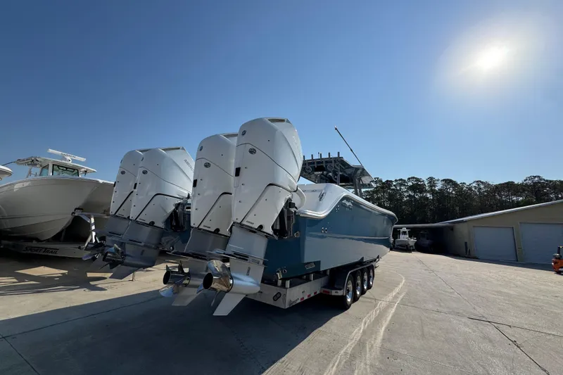 Slide: The Image of 2024 Invincible 46 Catamaran with multiple outboard engines on a trailer under clear sky. - 10