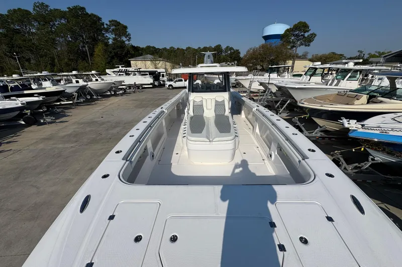 Slide: The Image of 2024 Invincible 46 Catamaran in a marina, showcasing spacious deck and seating. - 13