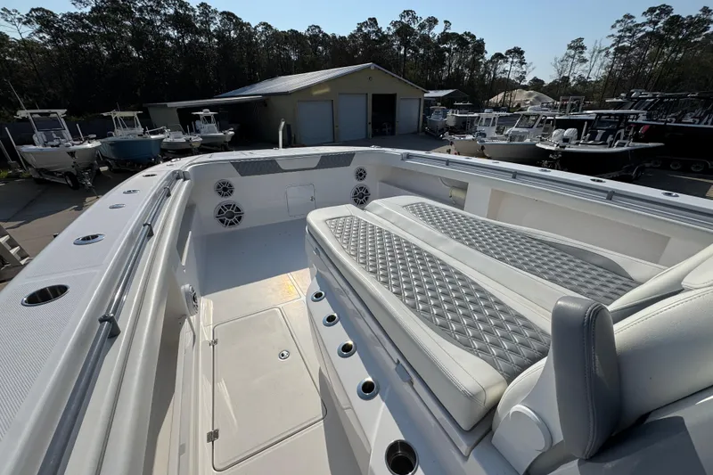 Slide: The Image of 2024 Invincible 46 Catamaran with spacious deck and luxurious seating in a marina setting. - 16