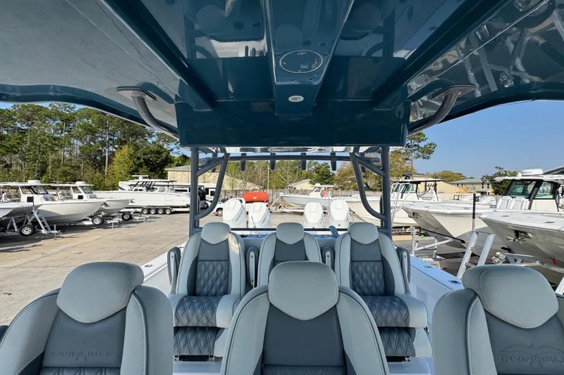 Slide: The Image of 2024 Invincible 46 Catamaran interior with luxurious seating, docked among other boats. - 23