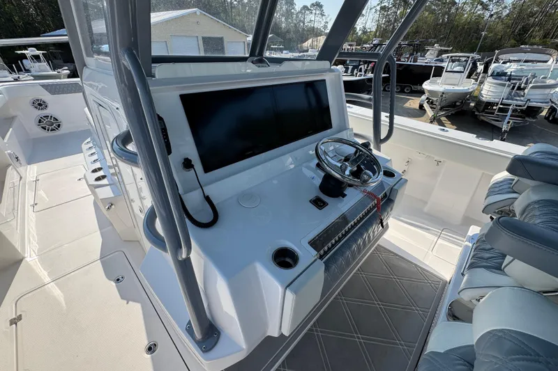 Slide: The Image of 2024 Invincible 46 Catamaran helm with modern controls and seating in a marina setting. - 26