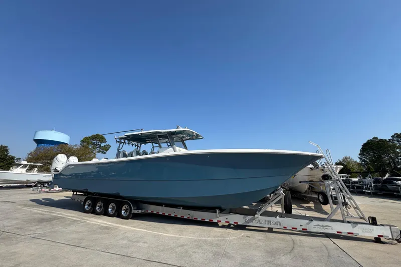 Slide: The Image of 2024 Invincible 46 Catamaran on trailer under clear blue sky. - 3