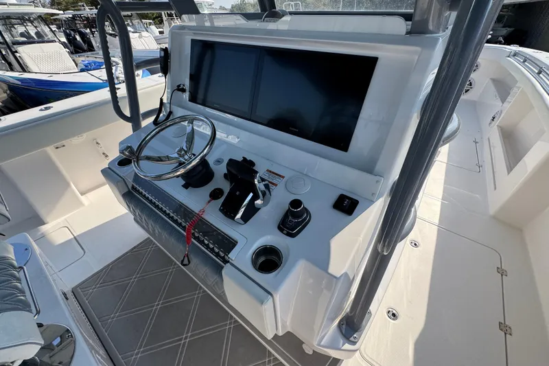 Slide: The Image of 2024 Invincible 46 Catamaran helm with steering wheel and navigation screens. - 30