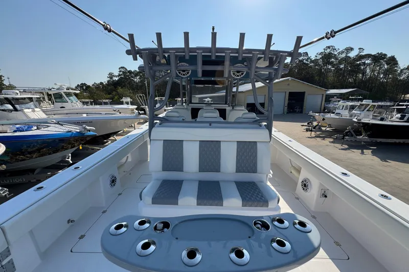 Slide: The Image of 2024 Invincible 46 Catamaran interior with seating and rod holders, docked at a marina. - 32