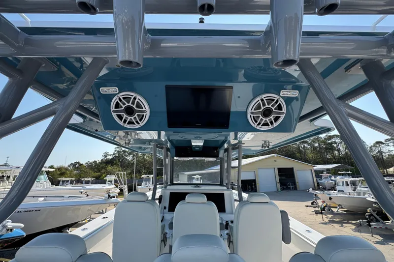 Slide: The Image of 2024 Invincible 46 Catamaran interior with speakers and seating, docked at a marina. - 34