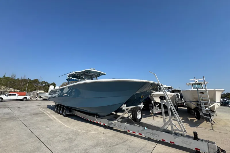 Slide: The Image of 2024 Invincible 46 Catamaran on trailer under clear blue sky. - 4