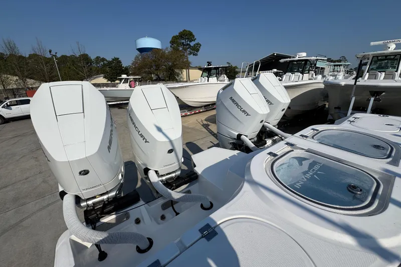 Slide: The Image of 2024 Invincible 46 Catamaran with Mercury outboard engines in a marina setting. - 41