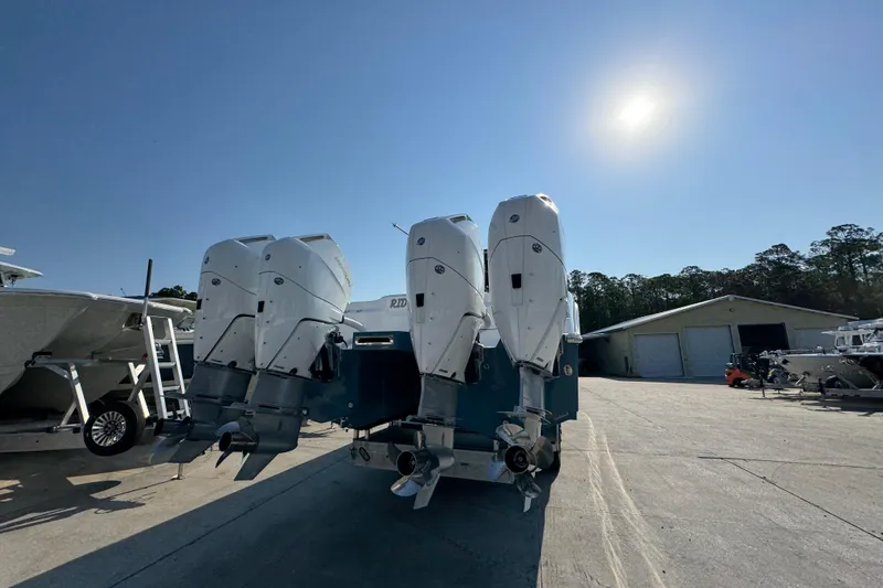 Slide: The Image of 2024 Invincible 46 Catamaran with quad outboard engines in a sunny boatyard. - 9